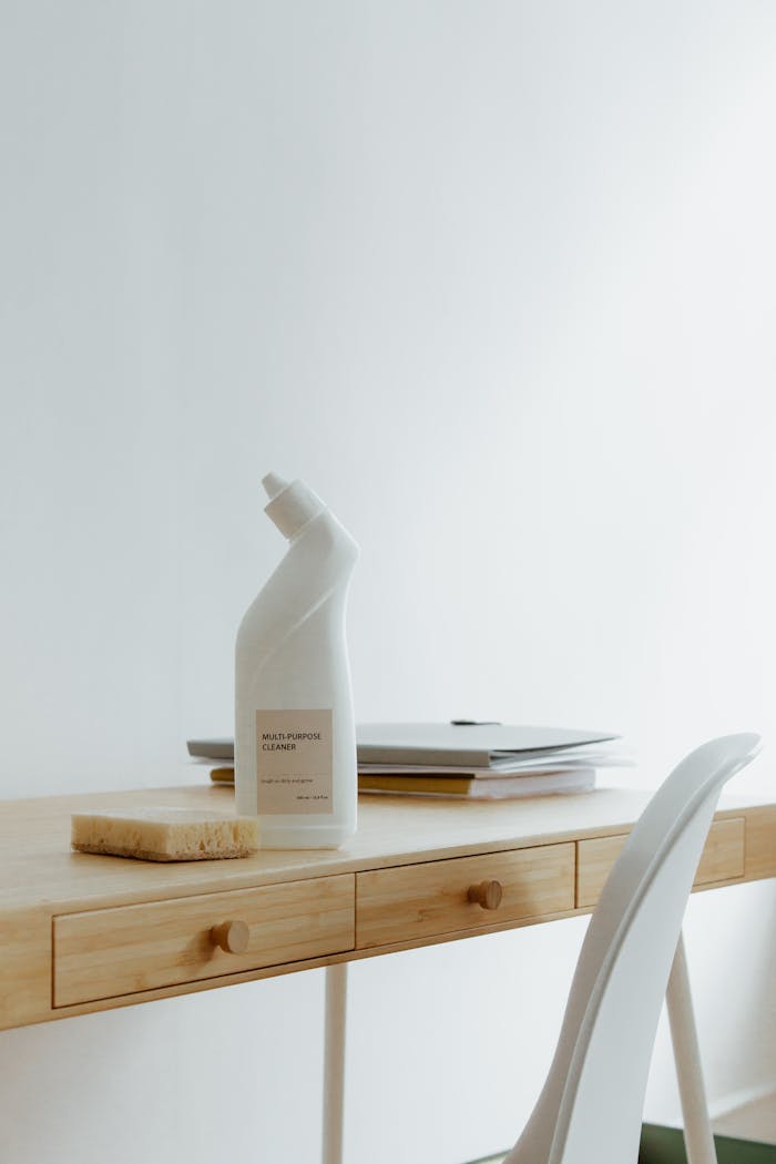 services-03 A clean and organized home office desk with a cleaner bottle and sponge, emphasizing simplicity and functionality.