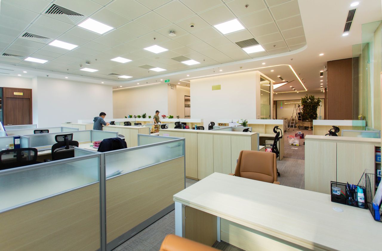 services-02 Bright and spacious office interior featuring open-plan cubicles, modern furniture, and ceiling lights.